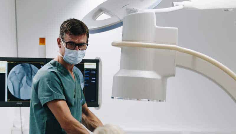 Bilde av Dr. Knut Egill Parrington Hansen som står inne på et behandlingsrom under en røntgenundersøkelse - Stamcelleklinikken - Artrose